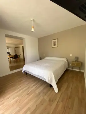 a bedroom with a large bed and a wooden floor at Calenzana GR20 in Calenzana