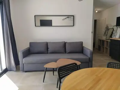 a living room with a couch and a table at Beau logement neuf à 5 mn de la mer in Ventiseri