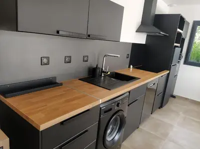 a kitchen with a sink and a washing machine at Beau logement neuf à 5 mn de la mer in Ventiseri