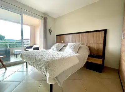 a bedroom with a large bed and a large window at Appartement Résidence Salin Bay in Porto-Vecchio