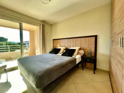 a bedroom with a large bed and a large window at Appartement Résidence Salin Bay in Porto-Vecchio