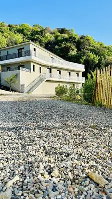 a large white building on a rocky road at A CASA DI GHJULIA PISCINE CHAUFFEE PROCHE St FLORENT in Vallecalle