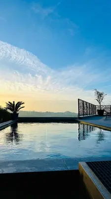 a pool of water with a palm tree in the background at A CASA DI GHJULIA PISCINE CHAUFFEE PROCHE St FLORENT in Vallecalle