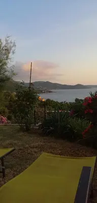 a green tennis court with a view of the water at Le repaire des pirates in Pietrosella