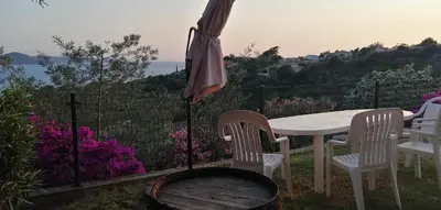 a table and chairs with an umbrella and a grill at Le repaire des pirates in Pietrosella