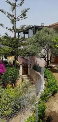 a fence in front of a building with trees and flowers at Le repaire des pirates in Pietrosella