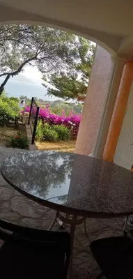 a table on a porch with a view of the ocean at Le repaire des pirates in Pietrosella