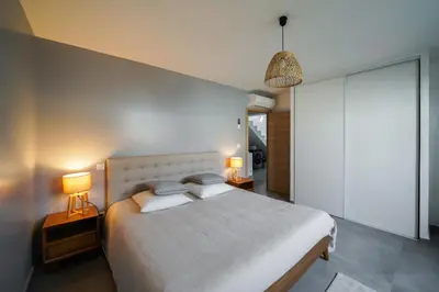 a bedroom with a large bed and two lamps at Très belle villa à Ghisonaccia avec piscine chauffée in Ghisonaccia