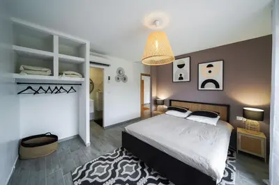a bedroom with a bed and a chandelier at Très belle villa à Ghisonaccia avec piscine chauffée in Ghisonaccia