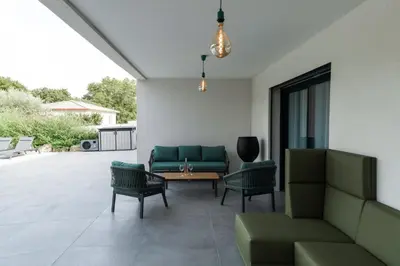 a patio with a couch and chairs and a table at Très belle villa à Ghisonaccia avec piscine chauffée in Ghisonaccia