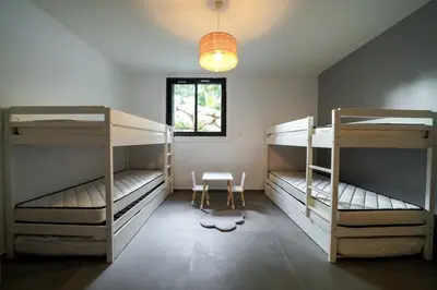 a room with three bunk beds and a window at Très belle villa à Ghisonaccia avec piscine chauffée in Ghisonaccia