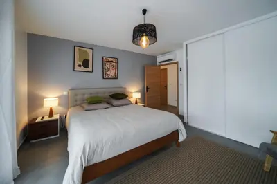 a bedroom with a large bed and two lamps at Très belle villa à Ghisonaccia avec piscine chauffée in Ghisonaccia