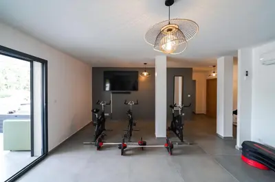 a gym with exercise bikes in a room with a window at Très belle villa à Ghisonaccia avec piscine chauffée in Ghisonaccia