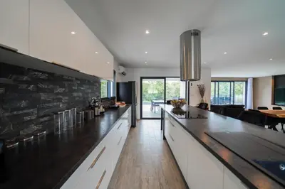 a kitchen with a long counter and a living room at Très belle villa à Ghisonaccia avec piscine chauffée in Ghisonaccia