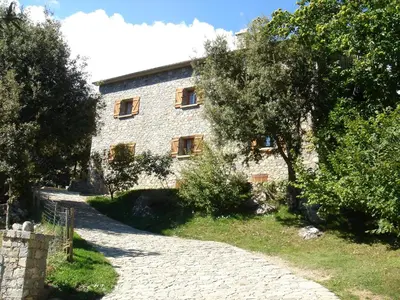 a stone building with trees in front of it at Chambre d'Hôte 
