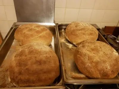 three loaves of bread in trays in a kitchen at Chambre d'Hôte 
