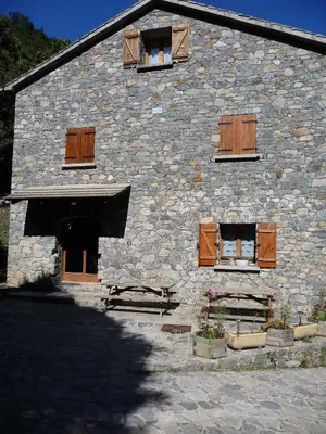 a stone building with wooden doors and windows at Chambre d'Hôte 