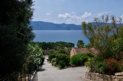 a walkway with a view of a body of water at Résidence Cantu di Mare in Olmeto