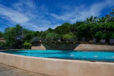 a swimming pool with blue water in a resort at Résidence Cantu di Mare in Olmeto