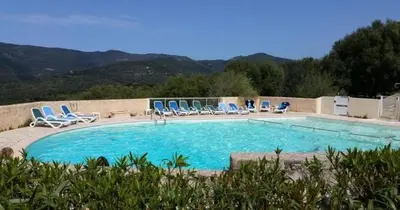a large swimming pool with blue chairs at MAISON ALBA ROSSA 55 in Serra-di-Ferro