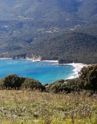 a view of a beach with blue water and mountains at MAISON ALBA ROSSA 55 in Serra-di-Ferro