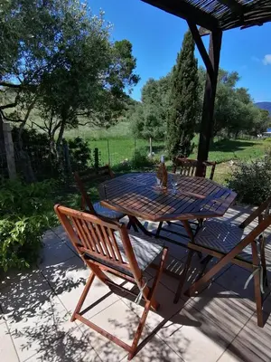 a picnic table and two chairs on a patio at MAISON ALBA ROSSA 55 in Serra-di-Ferro
