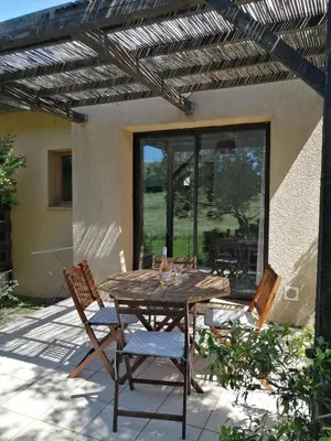 a wooden table and chairs on a patio at MAISON ALBA ROSSA 55 in Serra-di-Ferro