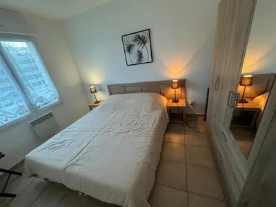 a bedroom with a white bed with two lamps at Charmant appartement dans résidence avec piscines in Santa-Maria-Poggio