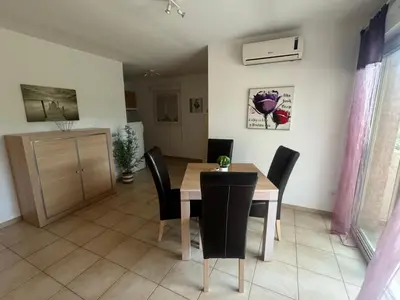 a kitchen and dining room with a table and chairs at Charmant appartement dans résidence avec piscines in Santa-Maria-Poggio