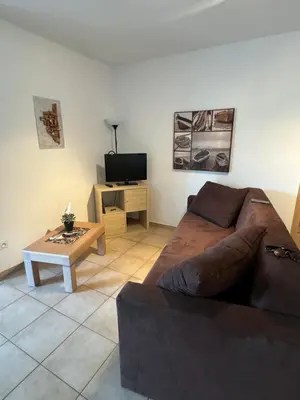 a living room with a couch and a coffee table at Charmant appartement dans résidence avec piscines in Santa-Maria-Poggio