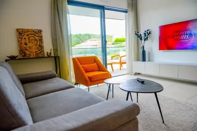 a living room with a couch and an orange chair at Livia - Agosta beach by foot Terrace - by TGB in Albitreccia