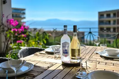 a bottle of wine sitting on a wooden table at Appartement vue mer aux sanguinaires - stationnement et ascenseur in Ajaccio