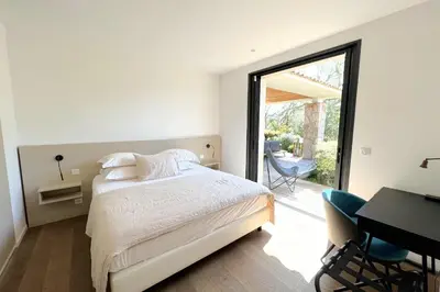 a bedroom with a bed and a desk and a window at Villa Pignotulli Di Cirendinu in Sainte-Lucie de Porto-Vecchio