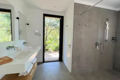 a bathroom with a shower and a white sink at Villa Pignotulli Di Cirendinu in Sainte-Lucie de Porto-Vecchio