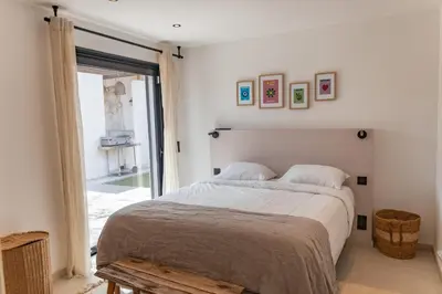 a bedroom with a large bed and a window at Villa Caipirinha Di Arasu in Sainte-Lucie de Porto-Vecchio