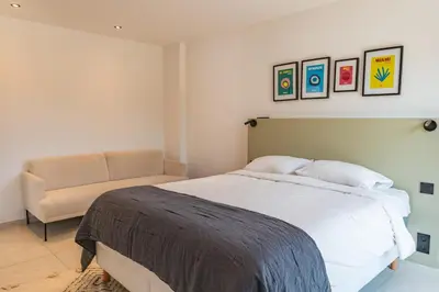 a bedroom with a bed and a chair at Villa Caipirinha Di Arasu in Sainte-Lucie de Porto-Vecchio