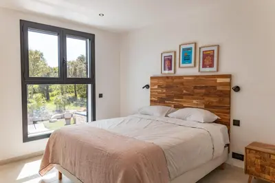 a bedroom with a large bed and a window at Villa Caipirinha Di Arasu in Sainte-Lucie de Porto-Vecchio