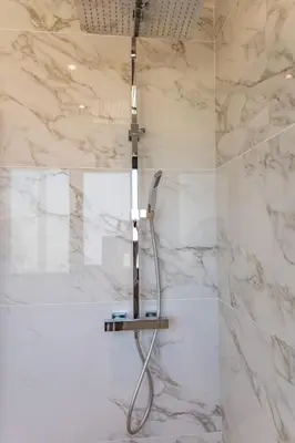 a shower in a bathroom with white marble walls at Villa Caipirinha Di Arasu in Sainte-Lucie de Porto-Vecchio