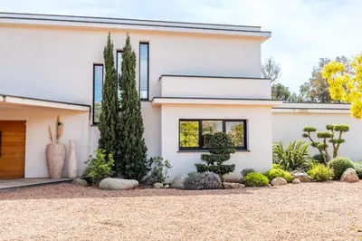 a white house with a lot of plants at Villa Caipirinha Di Arasu in Sainte-Lucie de Porto-Vecchio