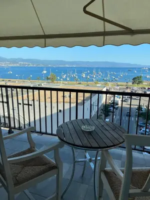 a table and chairs on a balcony with a view of the ocean at Appartement Ajaccio vue mer in Ajaccio