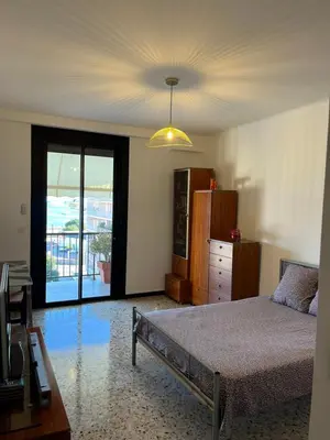 a bedroom with a bed and a dresser and a window at Appartement Ajaccio vue mer in Ajaccio