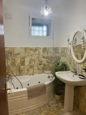a bathroom with a tub and a sink and a mirror at Appartement Ajaccio vue mer in Ajaccio