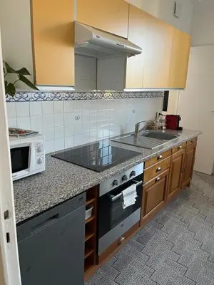a kitchen with a sink and a microwave at Appartement Ajaccio vue mer in Ajaccio
