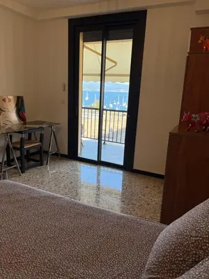 a living room with a door open to a balcony at Appartement Ajaccio vue mer in Ajaccio
