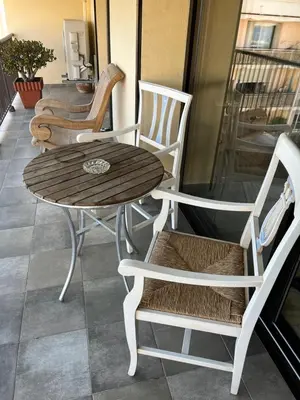 a wooden table and chairs on a balcony at Appartement Ajaccio vue mer in Ajaccio