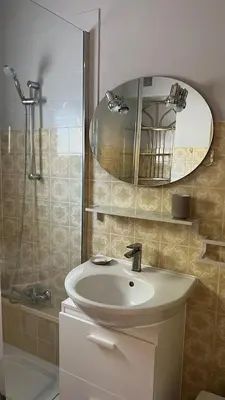 a bathroom with a sink and a shower with a mirror at LA CASA GIL in Ajaccio