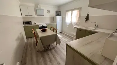 a kitchen with a table and a kitchen with green cabinets at LA CASA GIL in Ajaccio