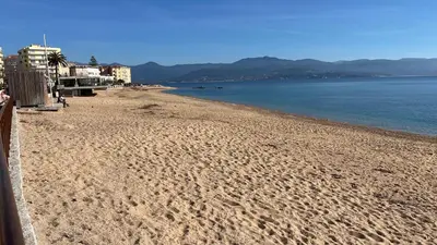a beach with footprints in the sand and the water at LA CASA GIL in Ajaccio