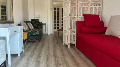 a living room with a red couch and a chair at LA CASA GIL in Ajaccio