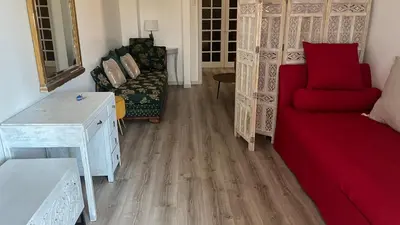 a living room with a red couch and a chair at LA CASA GIL in Ajaccio